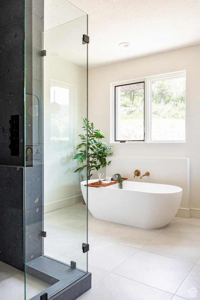 4107 W Crest Ct, Park City, UT 84098 - bathroom with plenty of natural light, a soaking tub, baseboards, and tile patterned flooring