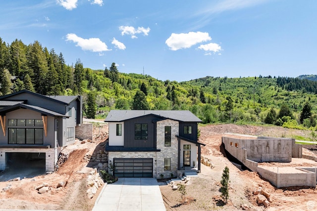 4107 W Crest Ct, Park City, UT 84098 - contemporary house featuring a view of trees, a garage, driveway, and stone siding