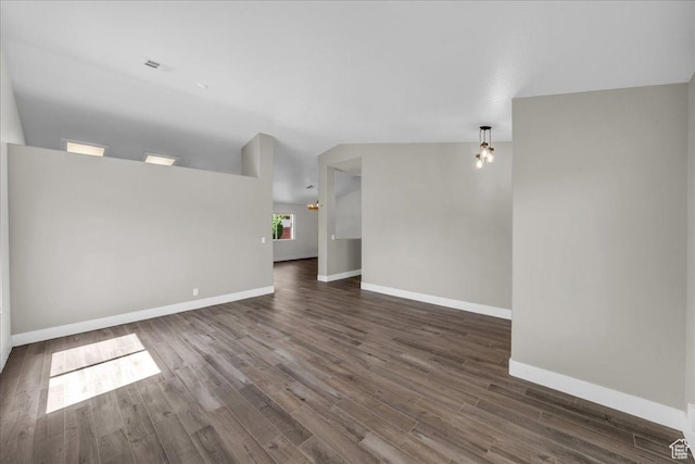 2461 W 1050 N, Hurricane, UT 84737 - unfurnished living room featuring baseboards, lofted ceiling, and dark wood-type flooring