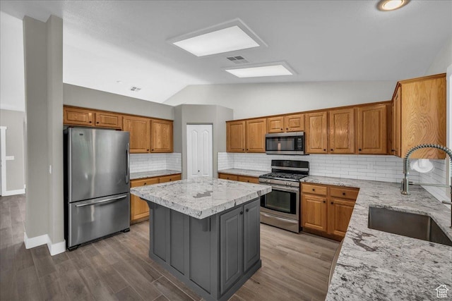 2461 W 1050 N, Hurricane, UT 84737 - kitchen featuring appliances with stainless steel finishes, a sink, a center island, lofted ceiling, and light stone countertops
