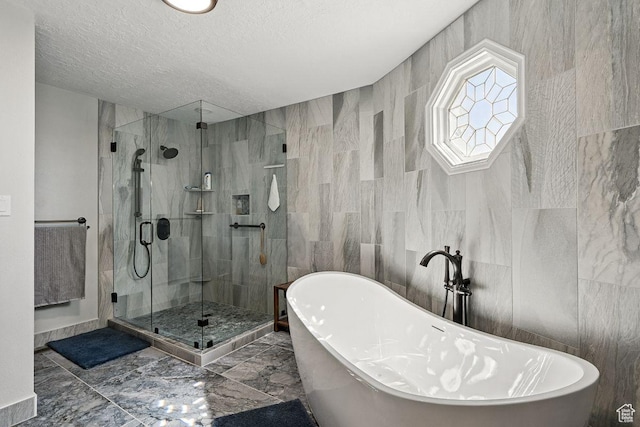 397 N Wendy Dr, Torrey, UT 84775 - bathroom featuring a stall shower, a textured ceiling, a soaking tub, marble finish flooring, and tile walls