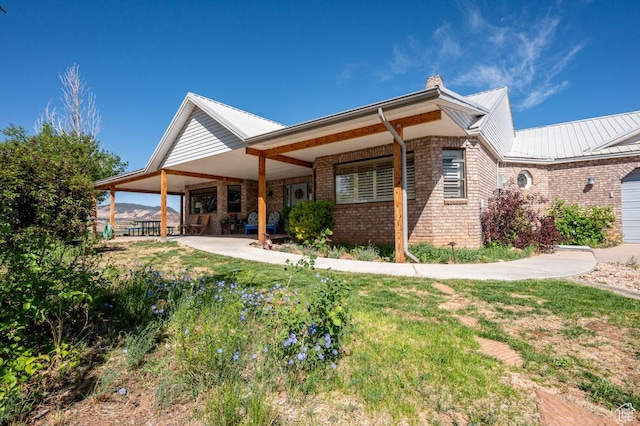 397 N Wendy Dr, Torrey, UT 84775 - back of house featuring brick siding, metal roof, a chimney, and a lawn