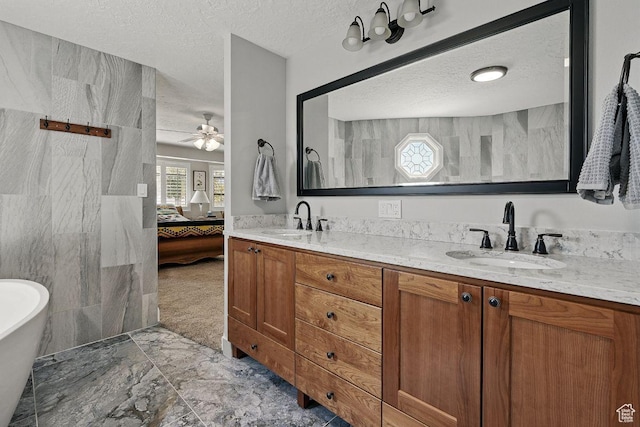 397 N Wendy Dr, Torrey, UT 84775 - ensuite bathroom with a textured ceiling, double vanity, marble finish floors, ceiling fan, and a soaking tub