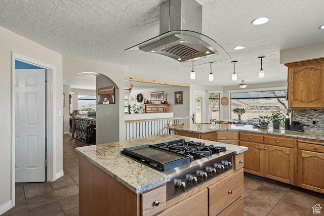 397 N Wendy Dr, Torrey, UT 84775 - kitchen with stainless steel gas cooktop, island exhaust hood, plenty of natural light, a peninsula, and a textured ceiling