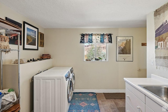 397 N Wendy Dr, Torrey, UT 84775 - washroom with washing machine and clothes dryer, baseboards, a textured ceiling, and cabinet space