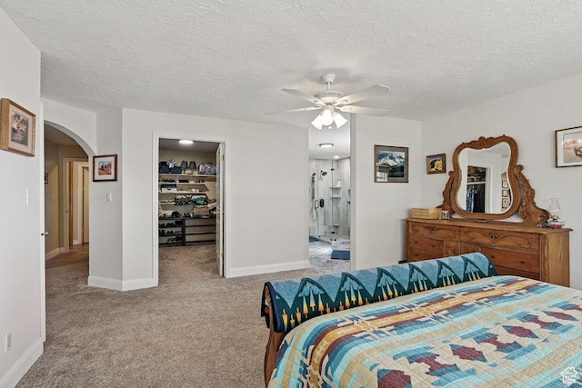 397 N Wendy Dr, Torrey, UT 84775 - bedroom with arched walkways, a walk in closet, carpet flooring, baseboards, and a textured ceiling