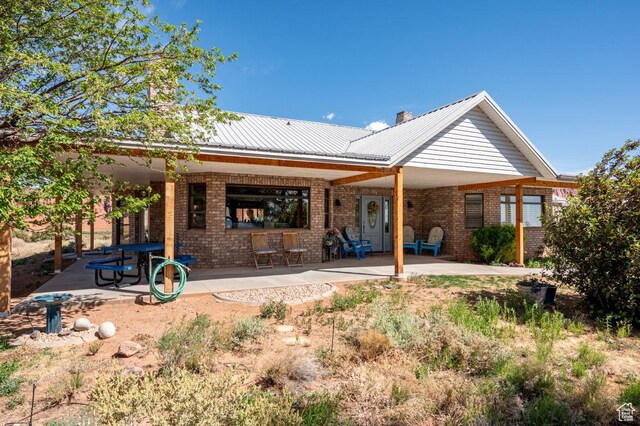397 N Wendy Dr, Torrey, UT 84775 - back of house featuring brick siding, a patio area, and metal roof