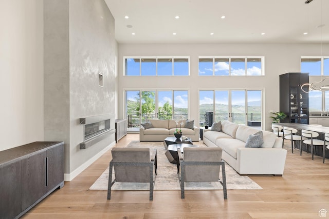3654 Aspen Camp Loop, Park City, UT 84098 - living room featuring recessed lighting, light wood-type flooring, healthy amount of natural light, a large fireplace, and a towering ceiling