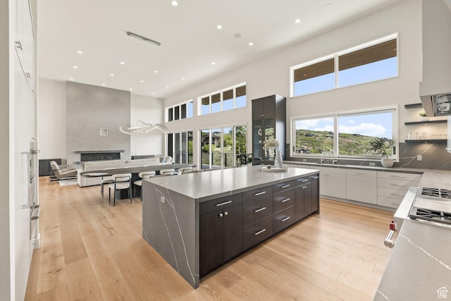 3654 Aspen Camp Loop, Park City, UT 84098 - kitchen featuring modern cabinets, a high ceiling, light wood finished floors, open floor plan, and a large island