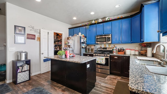 1002 W Stonehaven Dr Unit 108, North Salt Lake, UT 84054 - kitchen with appliances with stainless steel finishes, a sink, blue cabinetry, a kitchen island, and light stone countertops