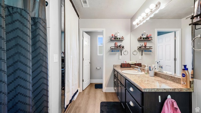 1002 W Stonehaven Dr Unit 108, North Salt Lake, UT 84054 - bathroom featuring wood finished floors, vanity, baseboards, and curtained shower