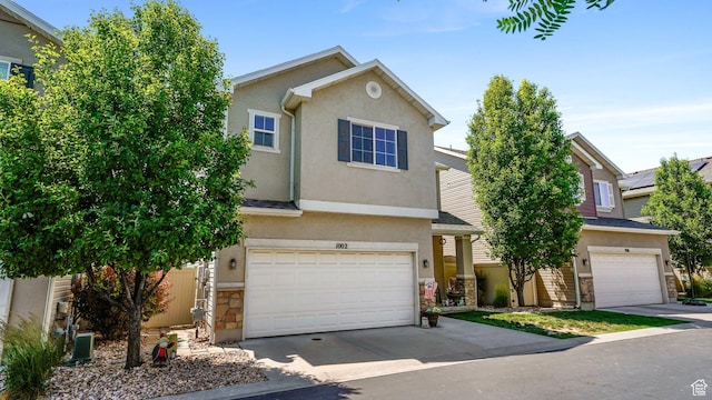1002 W Stonehaven Dr Unit 108, North Salt Lake, UT 84054 - view of front of property with stone siding, stucco siding, an attached garage, and concrete driveway