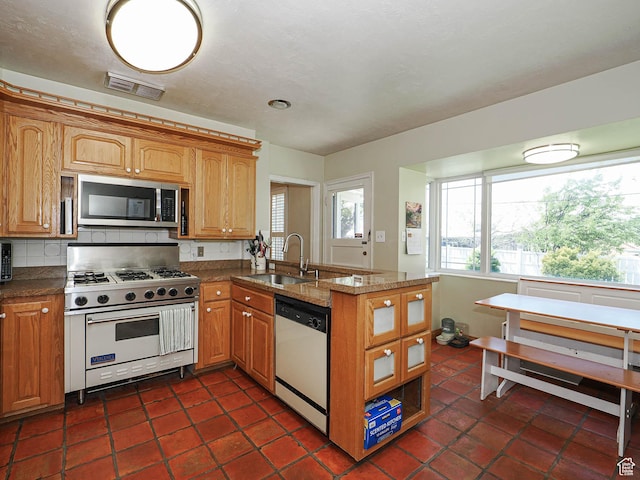 2244 E Laird Way, Salt Lake City, UT 84108 - kitchen featuring stainless steel appliances, a sink, a peninsula, brown cabinets, and dark stone countertops