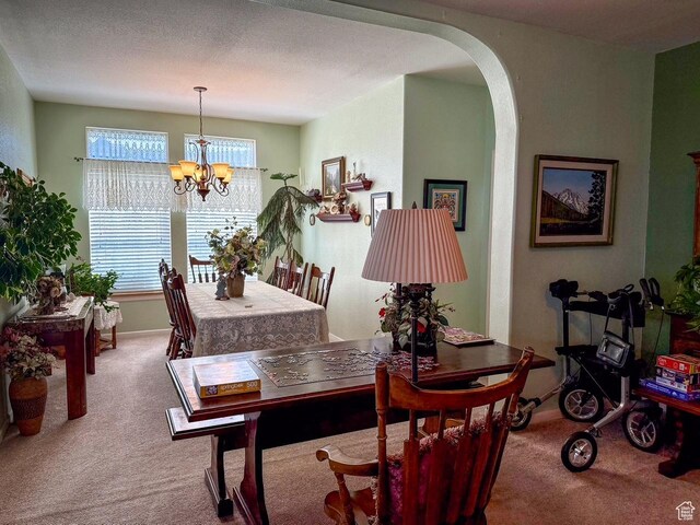 2780 S Bunch Grass Dr Unit 16, Garden City, UT 84028 - carpeted dining room featuring a chandelier and arched walkways