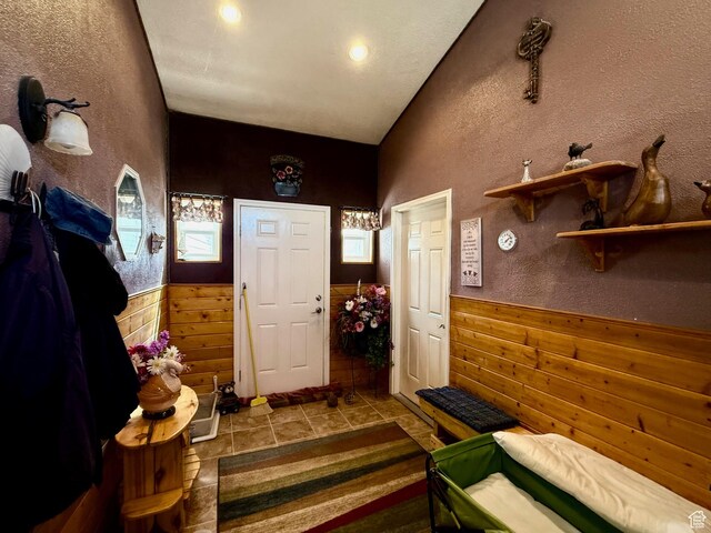 2780 S Bunch Grass Dr Unit 16, Garden City, UT 84028 - foyer featuring wainscoting, healthy amount of natural light, wooden walls, tile patterned flooring, and a textured wall