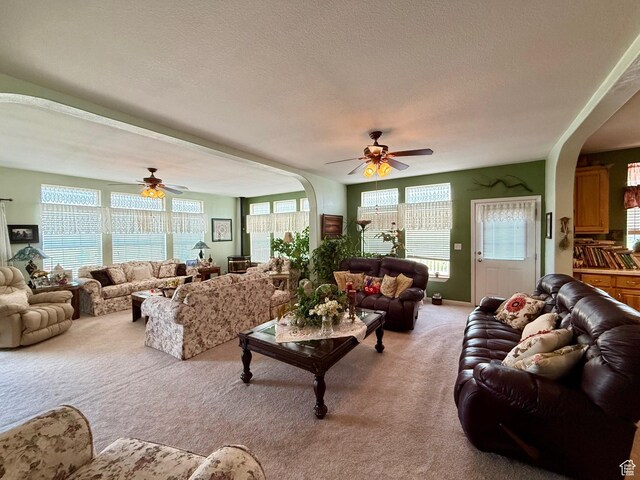 2780 S Bunch Grass Dr Unit 16, Garden City, UT 84028 - living room featuring arched walkways, light carpet, a ceiling fan, and a textured ceiling