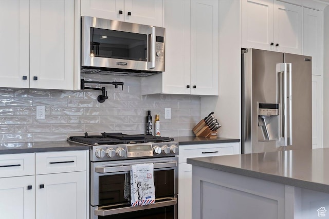 1494 W Lincoln Way, Kaysville, UT 84037 - kitchen featuring appliances with stainless steel finishes, dark countertops, white cabinetry, and backsplash