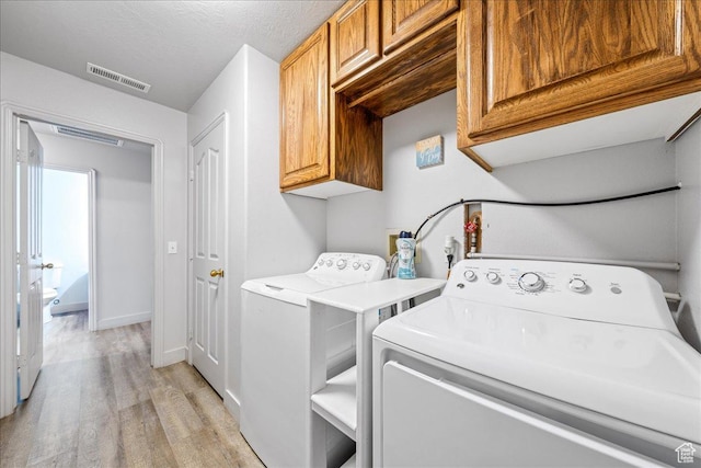 2811 E Paradise Way, St George, UT 84790 - laundry area featuring cabinet space, light wood finished floors, washing machine and clothes dryer, and baseboards