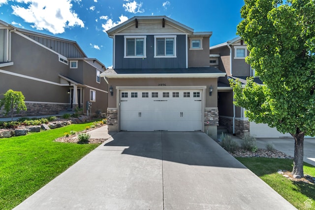 14496 S Edgemere Dr W, Herriman, UT 84096 - view of front of house with stone siding, an attached garage, a front yard, concrete driveway, and board and batten siding