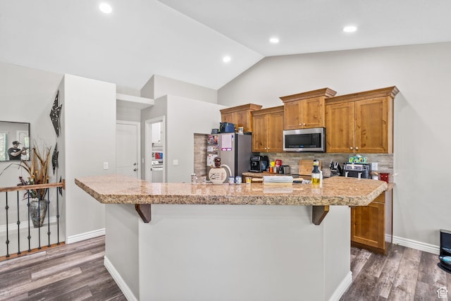 1809 E Kay Ln, South Weber, UT 84405 - kitchen with appliances with stainless steel finishes, light countertops, a kitchen bar, vaulted ceiling, and backsplash
