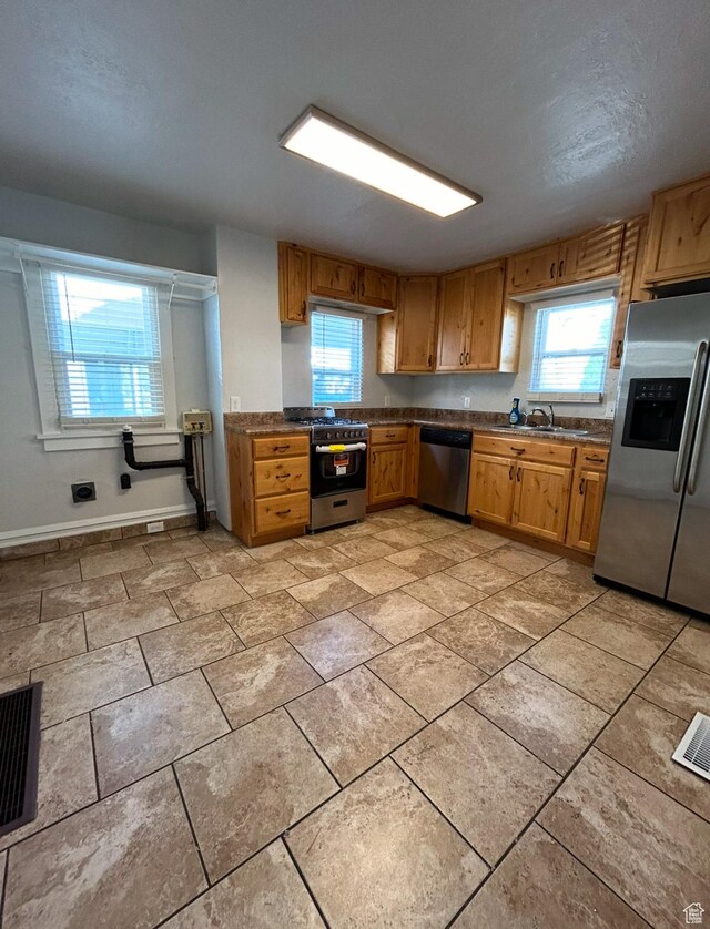 115 N 300 E, Payson, UT 84651 - kitchen featuring stainless steel appliances, dark countertops, brown cabinetry, and light tile patterned flooring