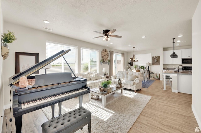 3154 S Edgewater Ln W, Syracuse, UT 84075 - living room featuring a ceiling fan, light wood-style flooring, a textured ceiling, recessed lighting, and baseboards