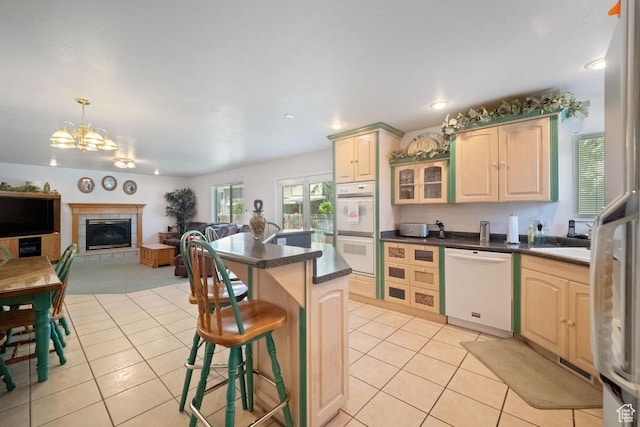 8298 S Arlington Ct, West Jordan, UT 84088 - kitchen featuring white appliances, light tile patterned floors, a chandelier, a breakfast bar area, and dark countertops