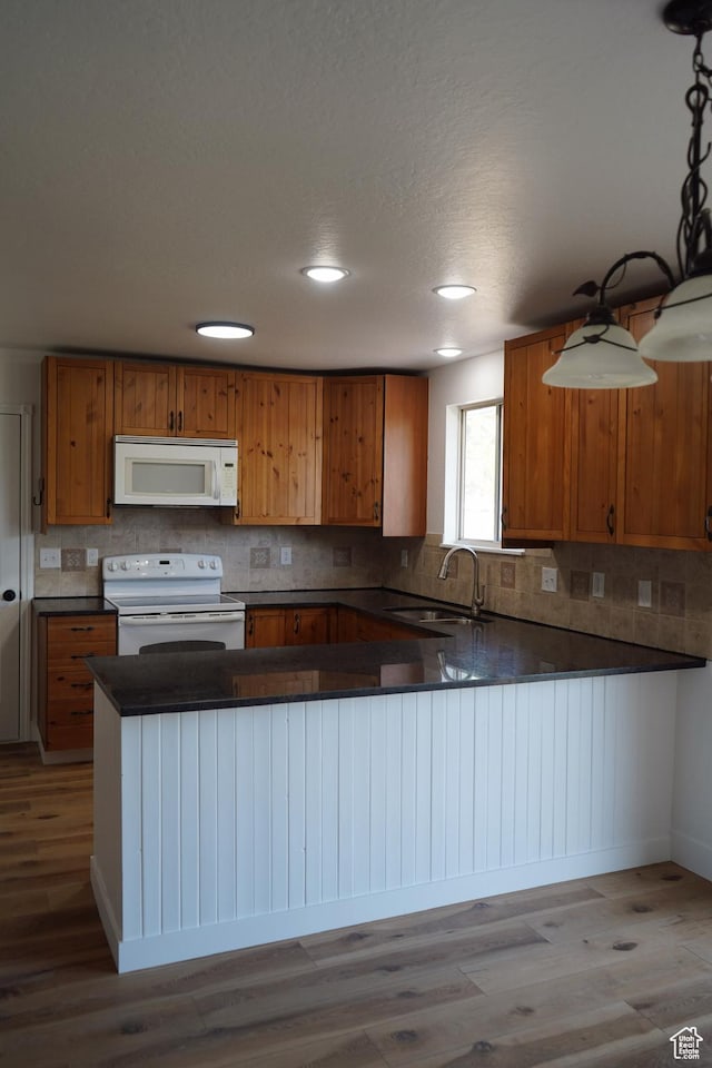 1102 E 120 S, Spanish Fork, UT 84660 - kitchen with white appliances, a sink, brown cabinetry, dark countertops, and wood finished floors