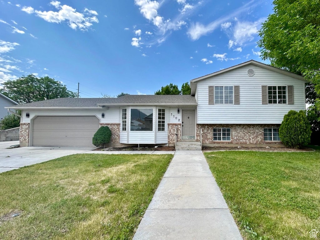 1102 E 120 S, Spanish Fork, UT 84660 - tri-level home featuring brick siding, a garage, concrete driveway, and a front yard