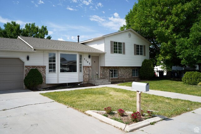 1102 E 120 S, Spanish Fork, UT 84660 - tri-level home featuring brick siding, a garage, a front lawn, concrete driveway, and a shingled roof