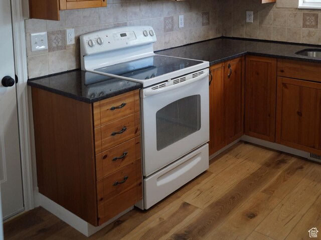 1102 E 120 S, Spanish Fork, UT 84660 - kitchen with white range with electric stovetop, light wood finished floors, brown cabinets, tasteful backsplash, and a sink