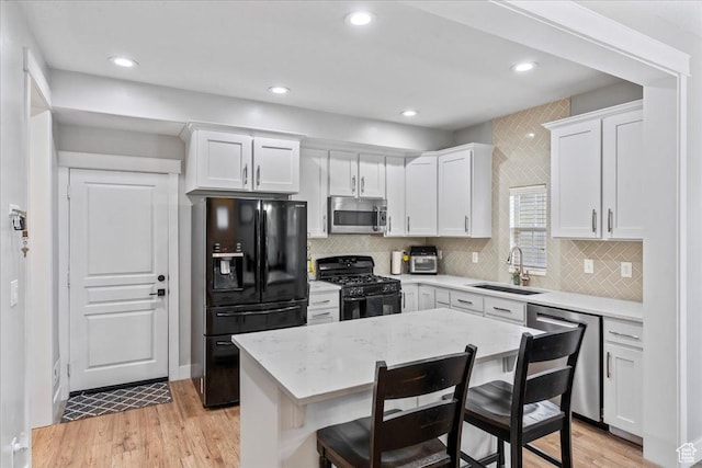 826 W 2630 N, Lehi, UT 84043 - kitchen with black appliances, a sink, white cabinets, a breakfast bar, and light wood-style flooring