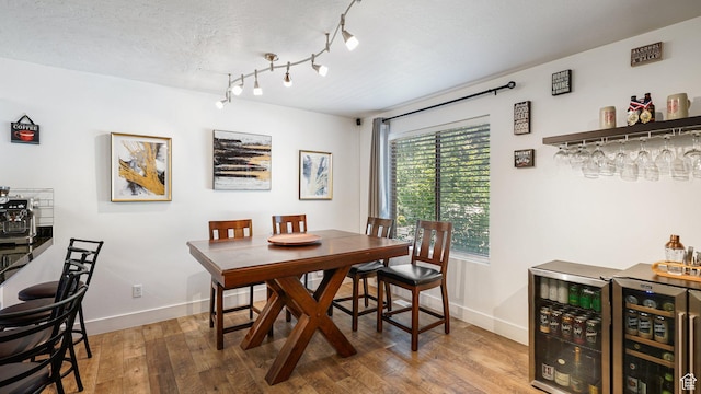 4475 S Lochnivar Ct E, Millcreek, UT 84107 - dining space featuring a bar, baseboards, wood finished floors, and wine cooler