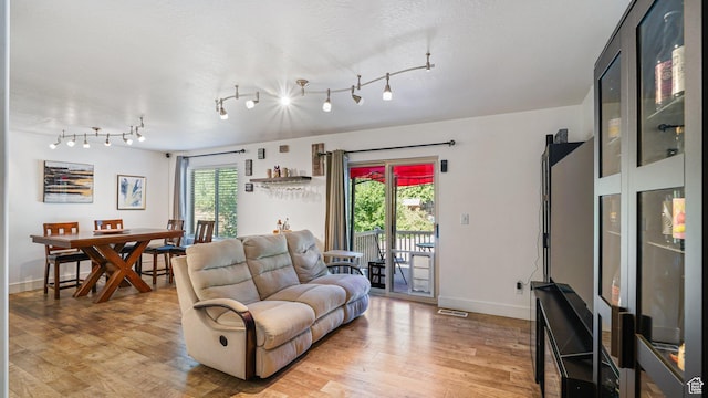 4475 S Lochnivar Ct E, Millcreek, UT 84107 - living room featuring light wood-style floors, baseboards, and rail lighting