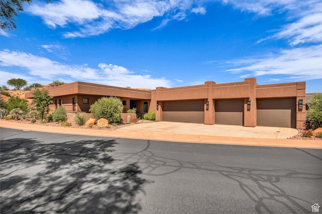 2304 N Cohonina Trl, St George, UT 84770 - pueblo revival-style home with stucco siding, driveway, and a garage
