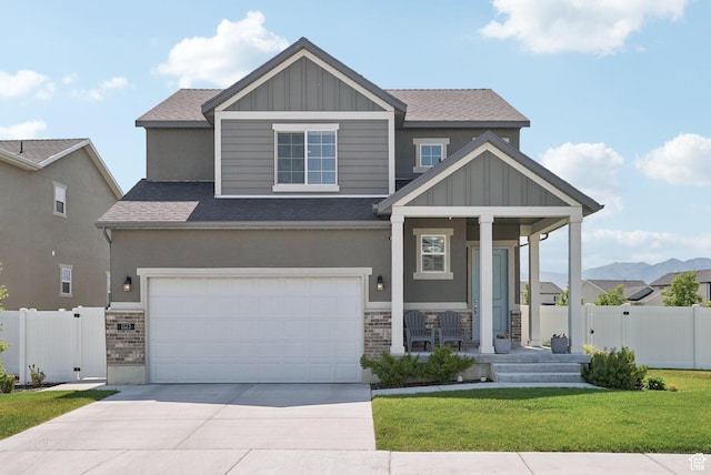 1123 W Osprey Dr, Stansbury Park, UT 84074 - craftsman house with covered porch, roof with shingles, driveway, brick siding, and board and batten siding