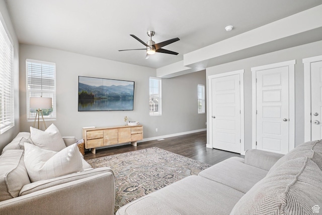 1123 W Osprey Dr, Stansbury Park, UT 84074 - living room featuring dark wood-type flooring, a ceiling fan, healthy amount of natural light, and baseboards
