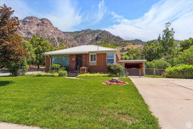 630 Polk Ave, Ogden, UT 84404 - view of front of house with driveway, a mountain view, a gate, and brick siding
