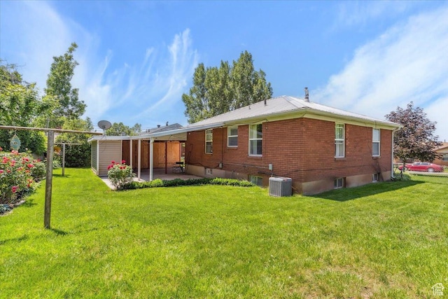 630 Polk Ave, Ogden, UT 84404 - rear view of house featuring a patio, central AC, a lawn, and brick siding