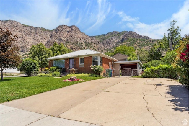 630 Polk Ave, Ogden, UT 84404 - view of front of house featuring driveway, a mountain view, brick siding, and a gate