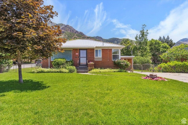 630 Polk Ave, Ogden, UT 84404 - view of front facade with a mountain view, a standing seam roof, brick siding, and metal roof