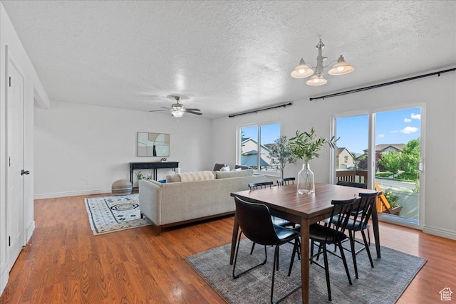 6286 W Anders Ridge Way S, West Valley City, UT 84128 - dining room featuring a textured ceiling, a ceiling fan, wood finished floors, a chandelier, and baseboards