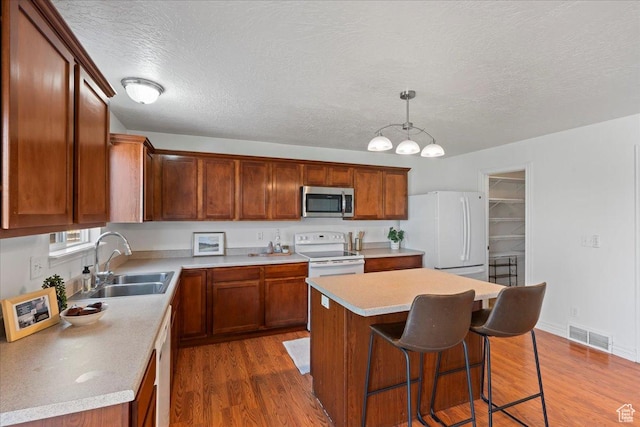6286 W Anders Ridge Way S, West Valley City, UT 84128 - kitchen with white appliances, a sink, dark wood-style floors, a center island, and a textured ceiling