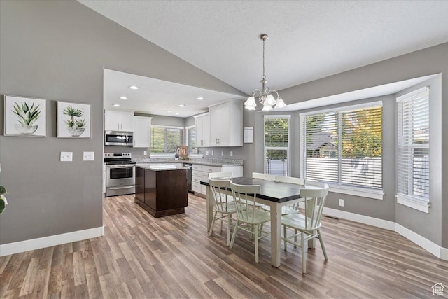 1628 W 1050 S, Syracuse, UT 84075 - dining space with vaulted ceiling, light wood-style floors, a chandelier, baseboards, and a textured ceiling