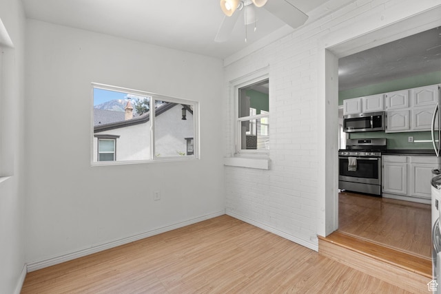 234 W 500 S, Provo, UT 84601 - unfurnished room with light wood-style flooring, a ceiling fan, brick wall, and baseboards