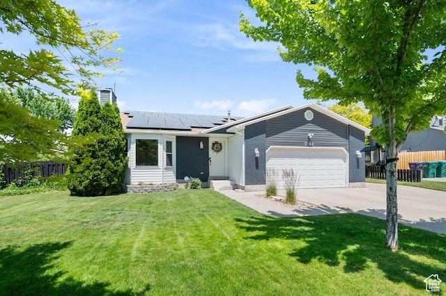 3186 W 5925 S, Roy, UT 84067 - view of front of property featuring driveway, an attached garage, roof mounted solar panels, and a chimney