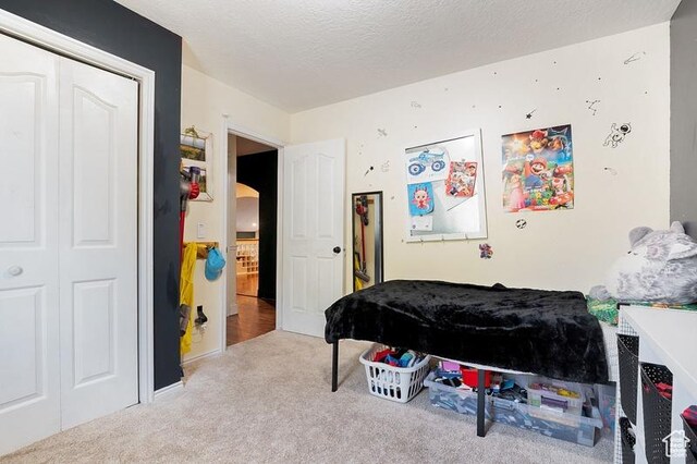 3186 W 5925 S, Roy, UT 84067 - carpeted bedroom featuring arched walkways, a closet, and a textured ceiling