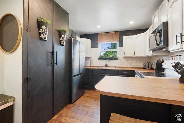 3186 W 5925 S, Roy, UT 84067 - kitchen featuring freestanding refrigerator, range, light wood-style floors, a sink, and white cabinets