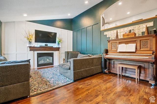 3186 W 5925 S, Roy, UT 84067 - living room featuring a decorative wall, vaulted ceiling, wood finished floors, a glass covered fireplace, and recessed lighting