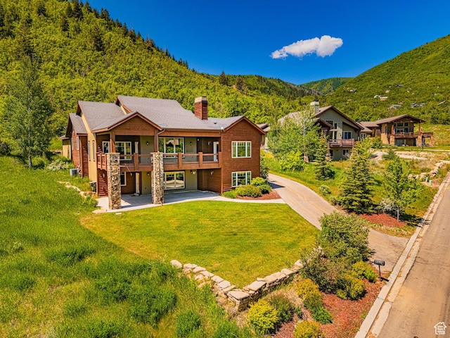 1273 W Lime Canyon Way, Midway, UT 84049 - rear view of property featuring a chimney, a lawn, driveway, a deck with mountain view, and a patio